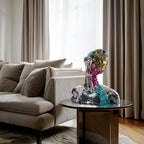 Luxury abstract geometric bust sculpture with reflective prism face detailing displayed on a modern glass coffee table in a contemporary living room