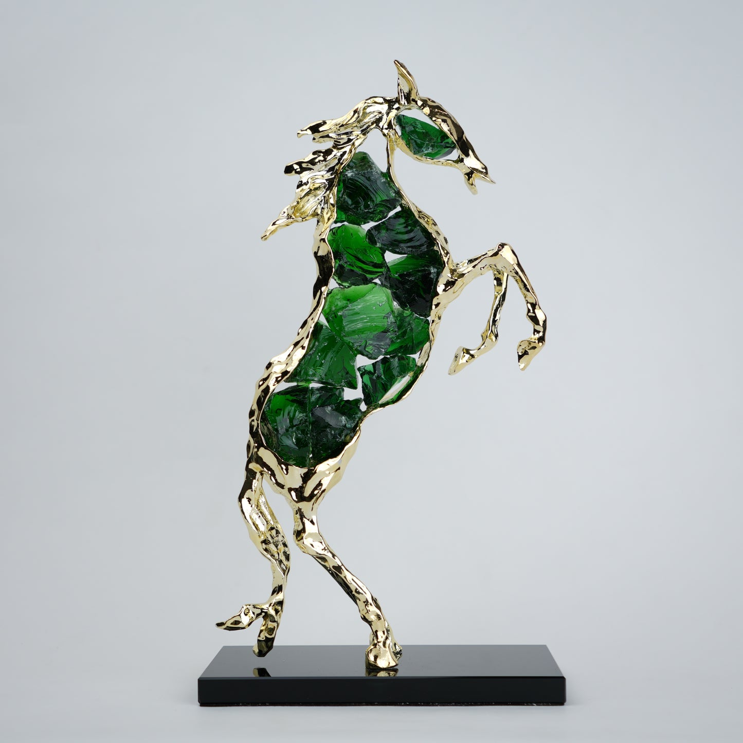Emerald crystal horse sculpture with gold finish in dynamic galloping form