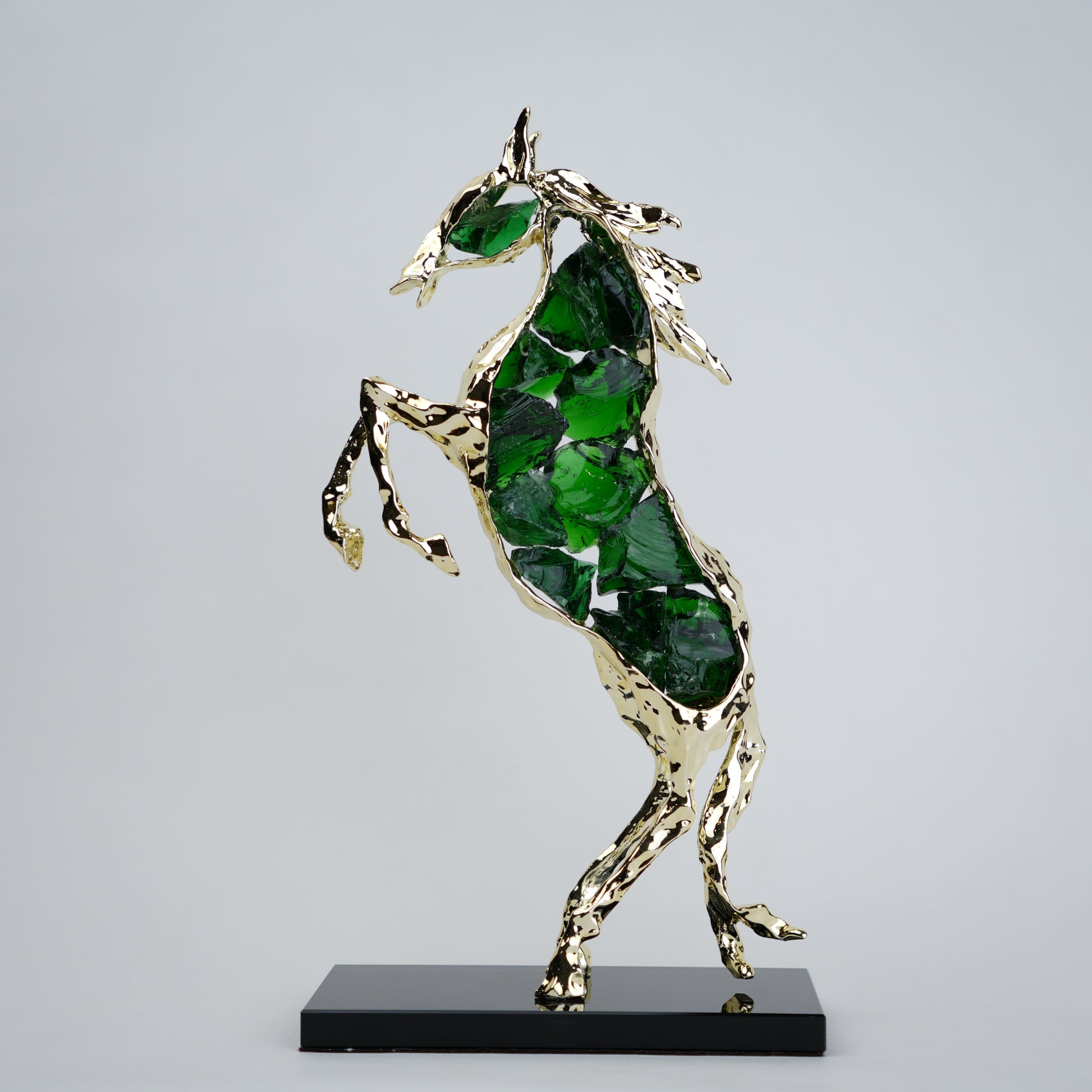 Emerald crystal horse sculpture with gold finish in dynamic galloping form
