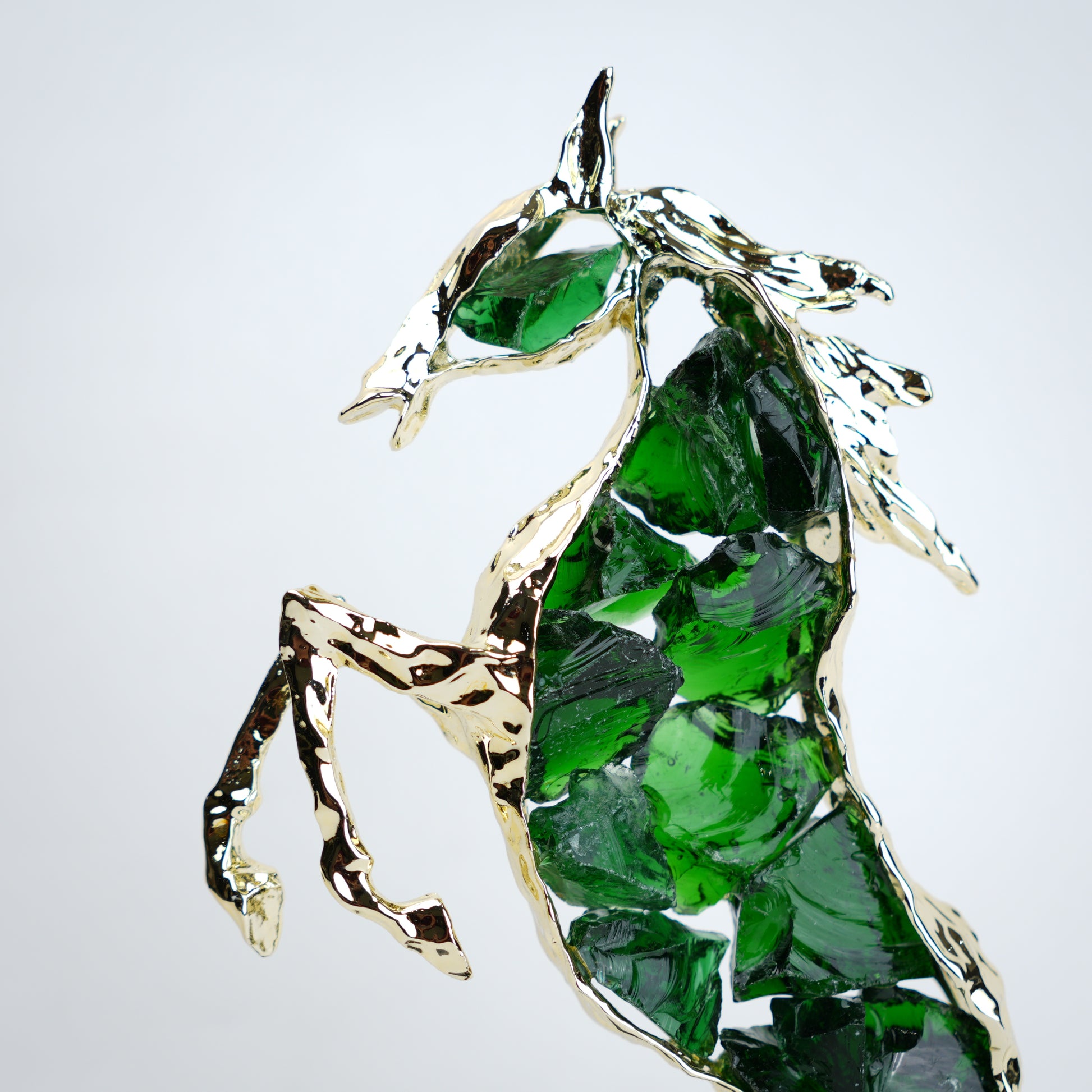 Emerald crystal horse sculpture with gold finish in dynamic galloping form