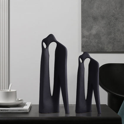 Matte black abstract loop decor accent with textured surface displayed on modern tabletop