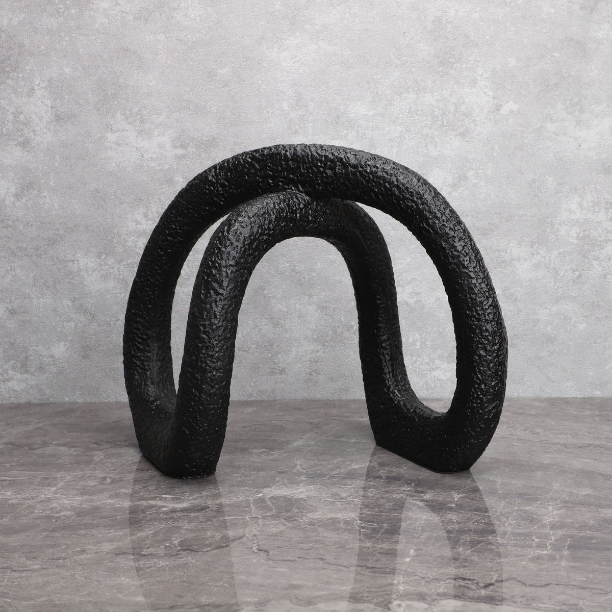 Black infinity loop on grey marble