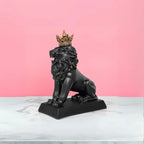 A matte black resin lion sculpture with a golden crown