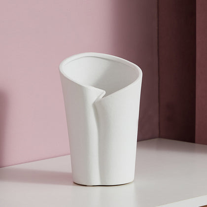 Luxury resin flower vase featuring a contemporary folded sculptural design, available in orange, white and black finishes, perfect for fresh flowers, dried botanicals and modern designer interiors.