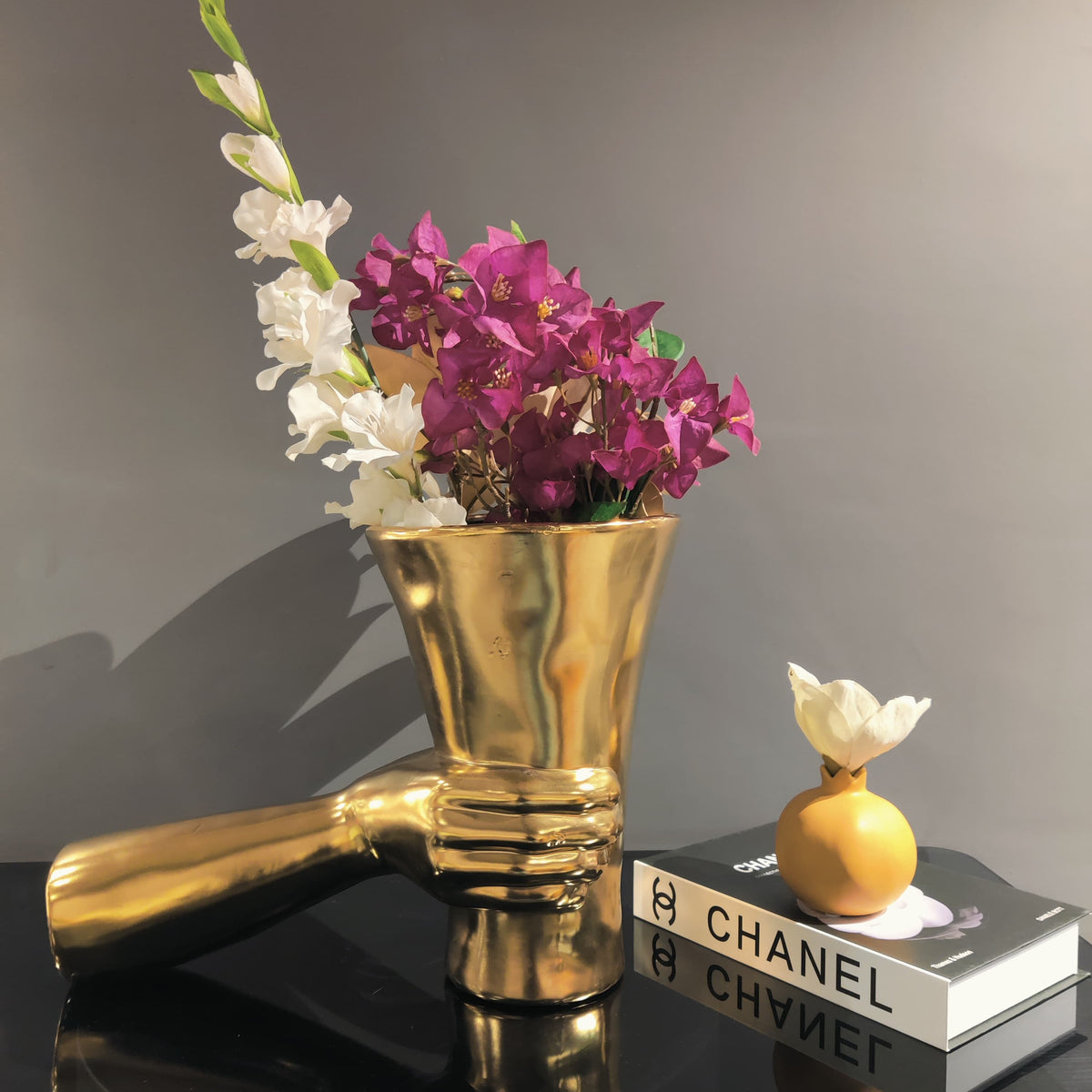 Premium gold vase with sculptural hand design for elegant floral presentation and interior styling