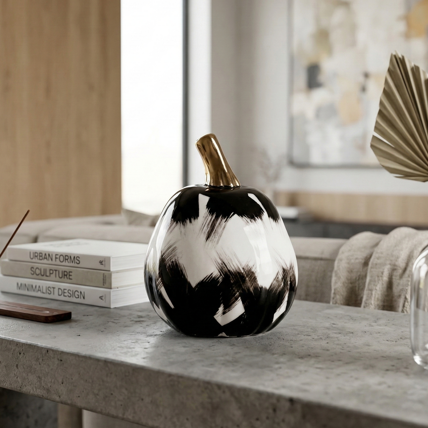 NoirLuxe pumpkin on concrete table, palm decor