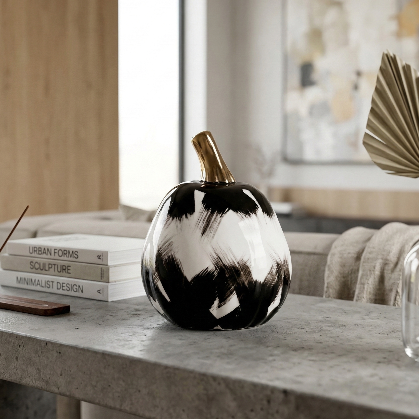 NoirLuxe pumpkin on concrete table, palm decor
