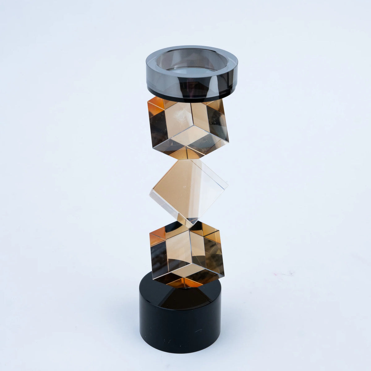 Faceted amber geometric candle stand with contrasting black cylindrical base