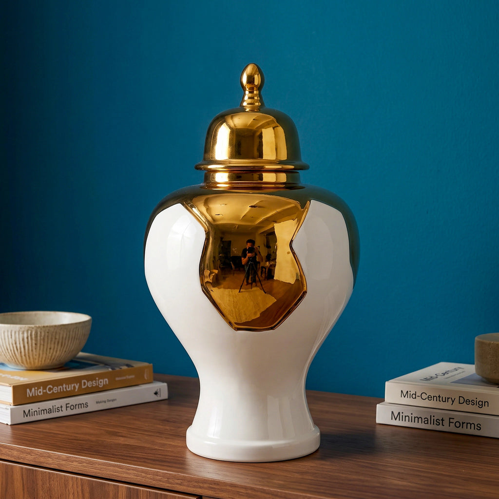 Ornate white and gold decorative vase  displayed on a wooden surface against a blue wall, with its lid placed beside it.