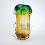 Glass vase with gradient green to amber color on a white background