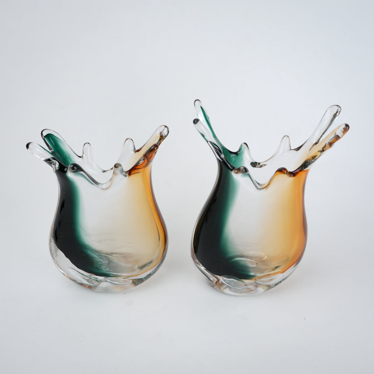 Green clear dual tone glass vase with an organic shape and uneven rim, featuring a thick base and smooth blended finish for modern home decor.