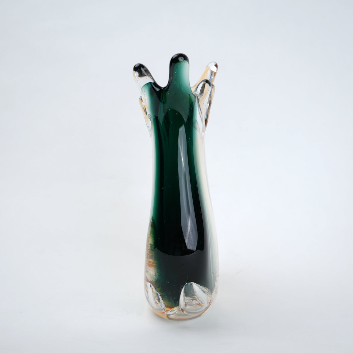 Green glass vase with a unique design on a white background