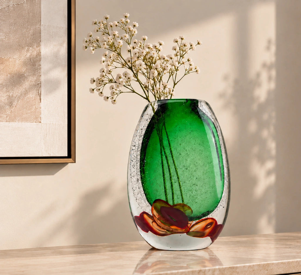 Decorative glass piece with green center and red and brown floral design on a white background