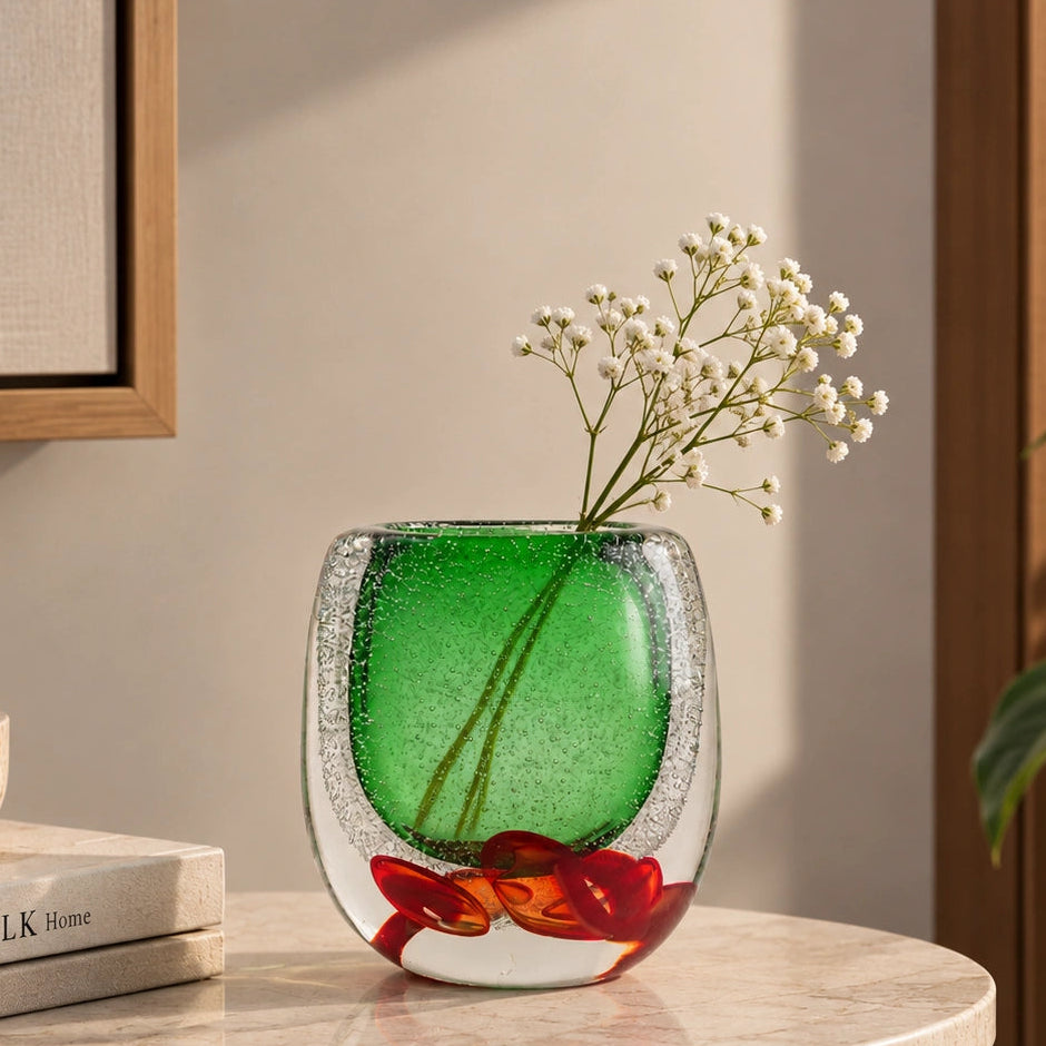 Decorative glass piece with green center and red and brown floral design on a white background