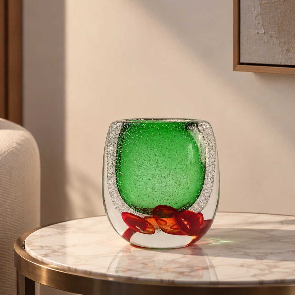 Decorative glass piece with green center and red and brown floral design on a white background