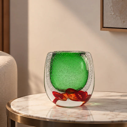 Decorative glass piece with green center and red and brown floral design on a white background