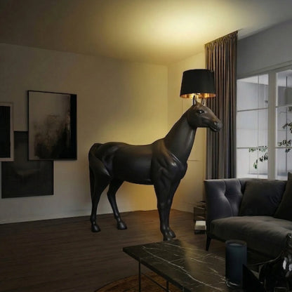Horse-shaped lamp in a modern living room with a couch and artwork on the wall.