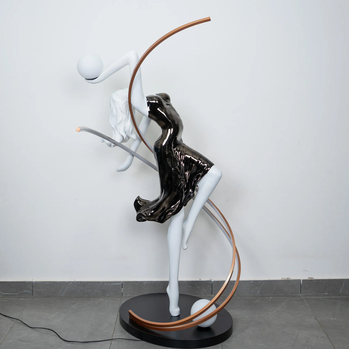 Black and white human figure floor lamp with bronze curved accents and round black base