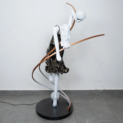 Black and white human figure floor lamp with bronze curved accents and round black base