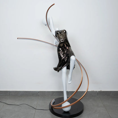 Black and white human figure floor lamp with bronze curved accents and round black base