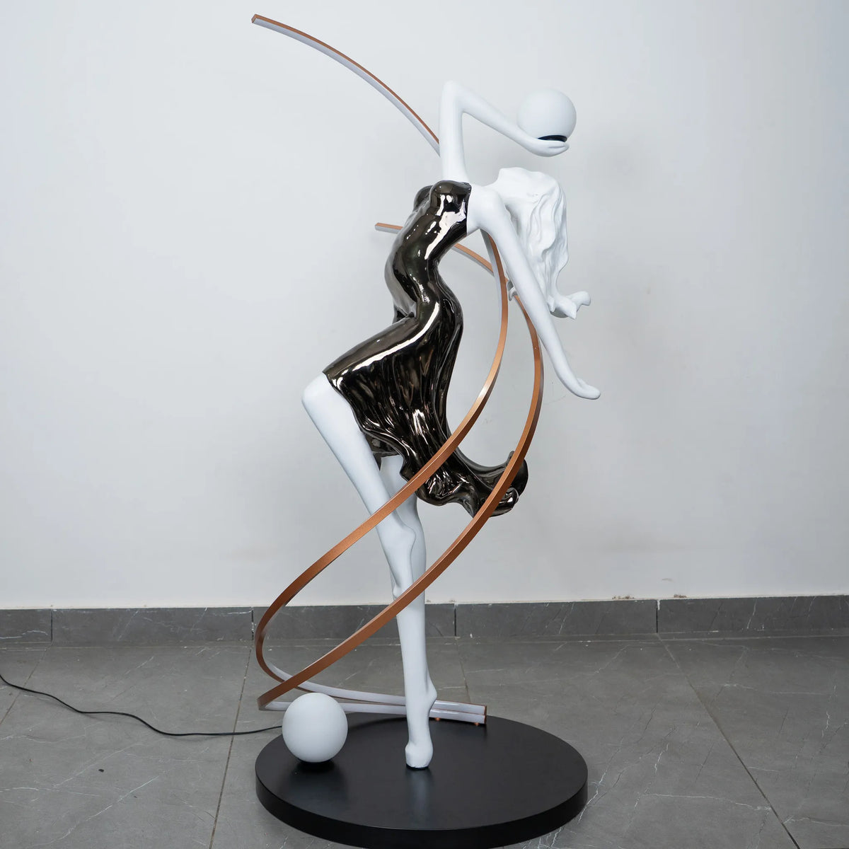Black and white human figure floor lamp with bronze curved accents and round black base