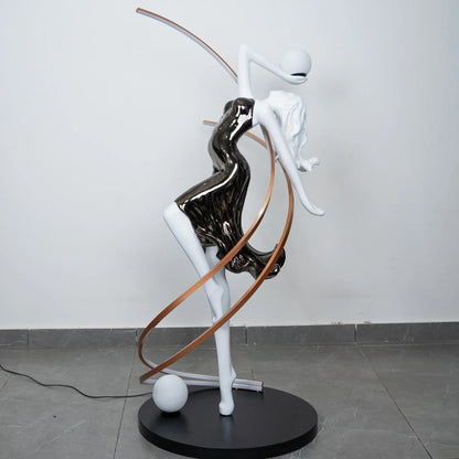 Black and white human figure floor lamp with bronze curved accents and round black base