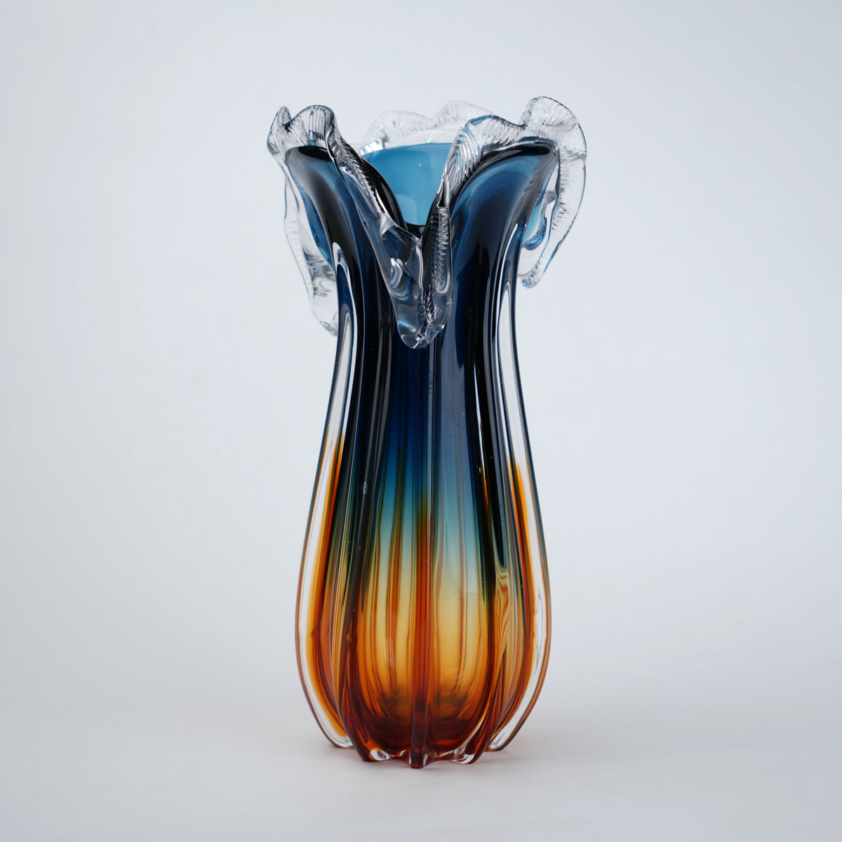 Glass vase with blue and orange gradient on a white background