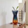 Blue gradient glass vase with multicolor base and clear flared rim