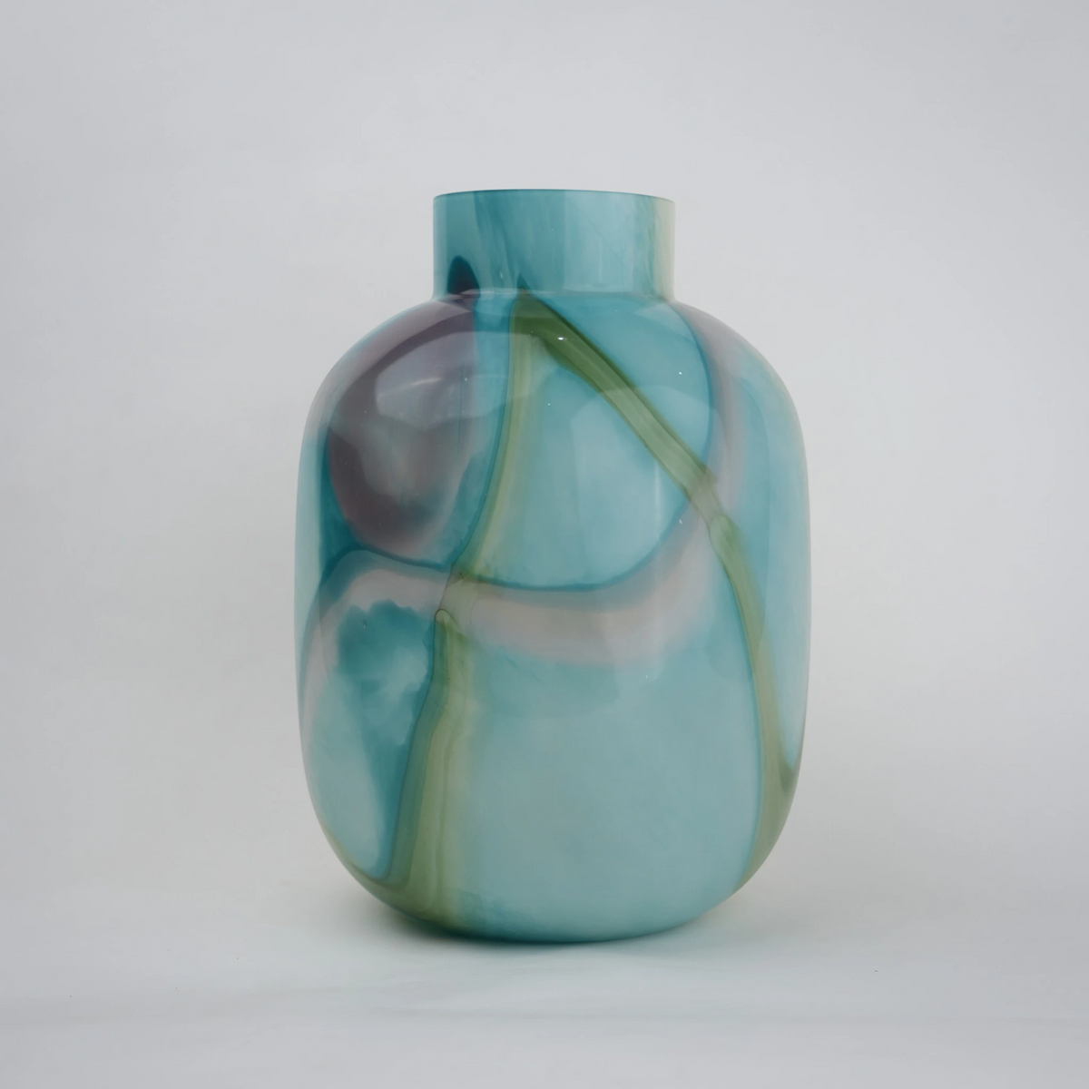 Blue marble effect glass vase with a smooth glossy finish, featuring a rounded body and short cylindrical neck, designed as a modern decorative piece for home decor styling.