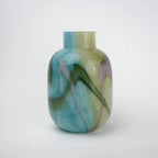 Blue marble effect glass vase with a smooth glossy finish, featuring a rounded body and short cylindrical neck, designed as a modern decorative piece for home decor styling.