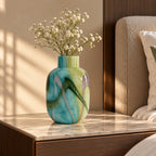 Blue marble effect glass vase with a smooth glossy finish, featuring a rounded body and short cylindrical neck, designed as a modern decorative piece for home decor styling.