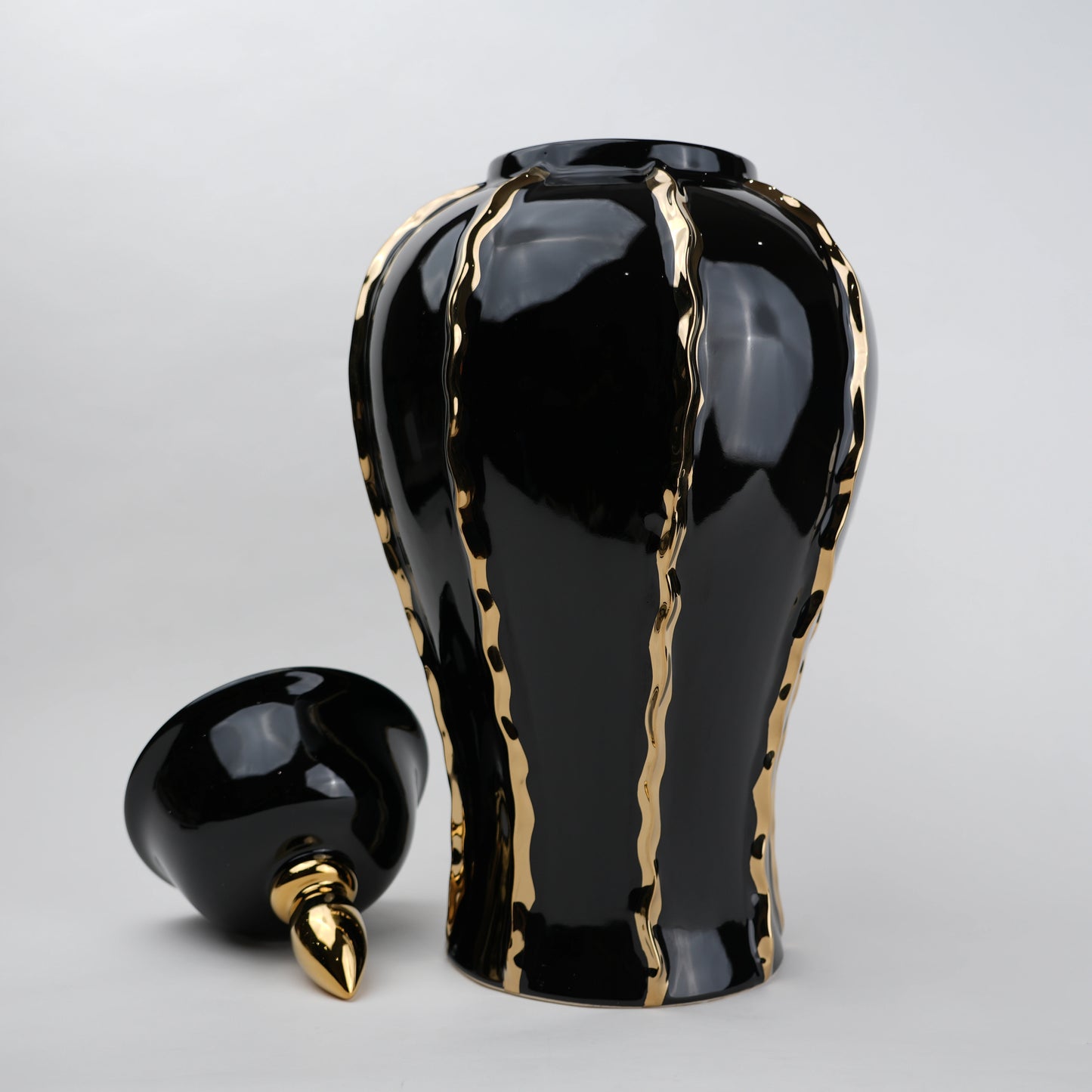 Black ceramic decorative jar with gold flowing accents and lid