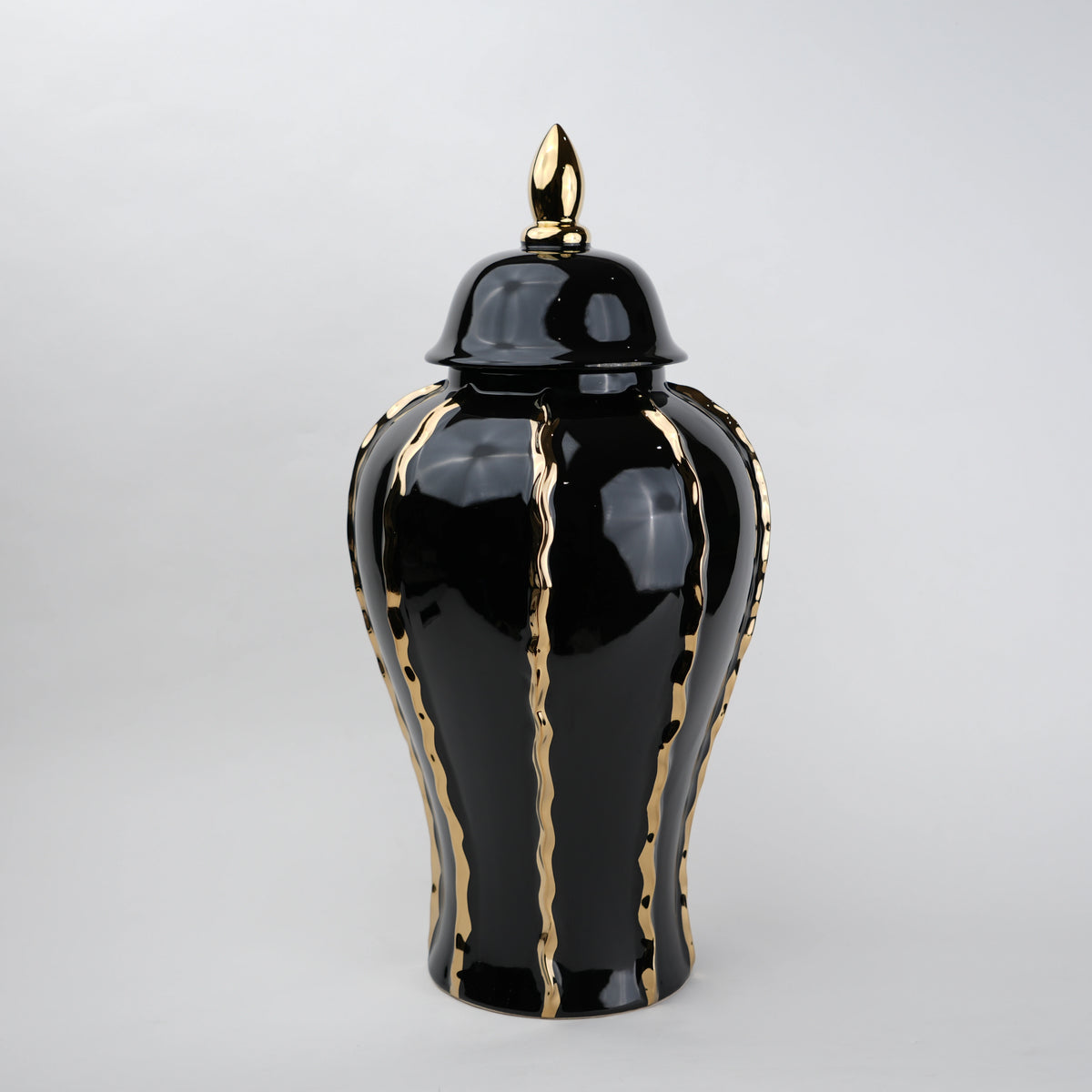 Black ceramic decorative jar with gold flowing accents and lid