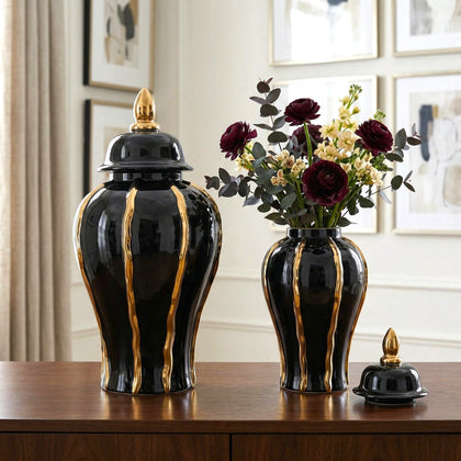 Set of black and gold ceramic vases on a wooden surface with a decorative background.