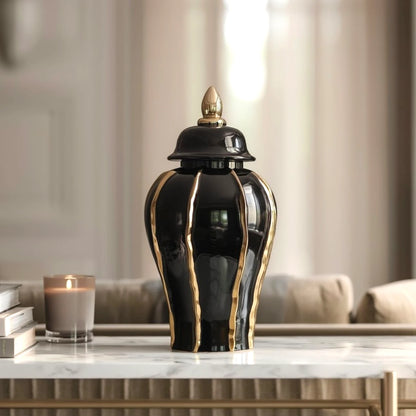 Black and gold decorative vase on a marble surface with a blurred indoor background