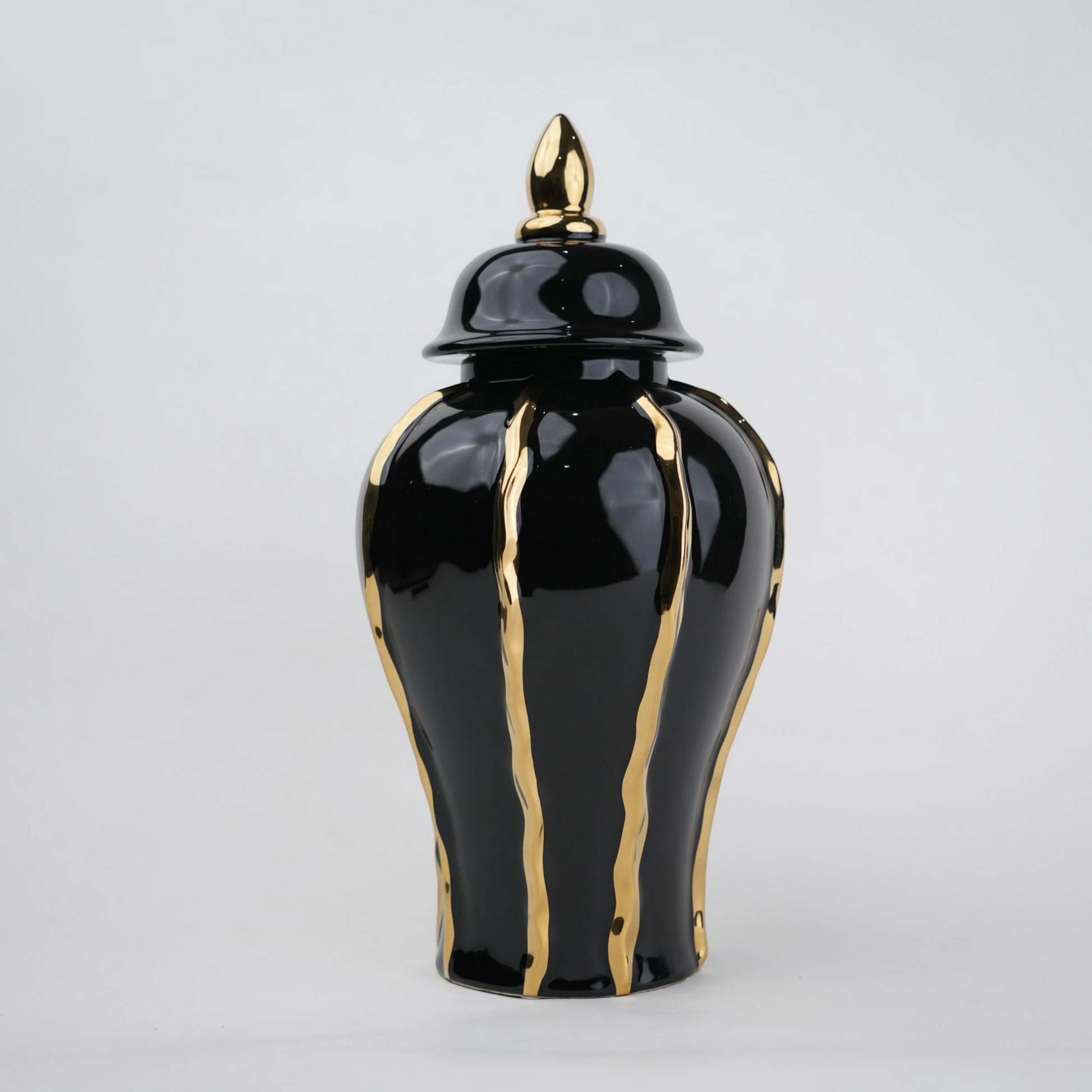 Black ceramic decorative jar with gold flowing accents and lid
