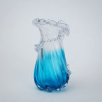 Glass vase with blue and clear design on a white background