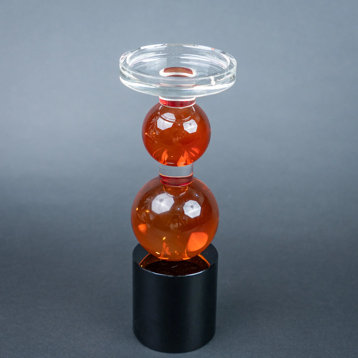 amber glass orb candle holder with black base modern decor