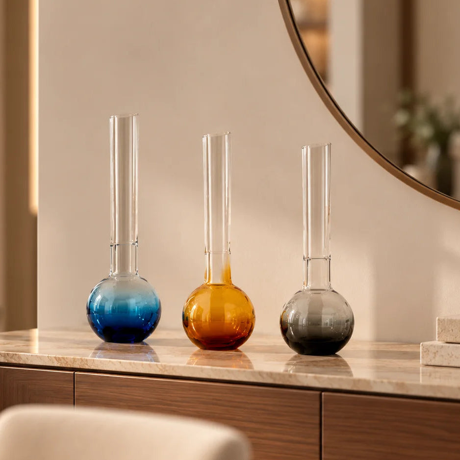 Glass vase with spherical base and elongated cylindrical neck designed for single stem floral arrangements