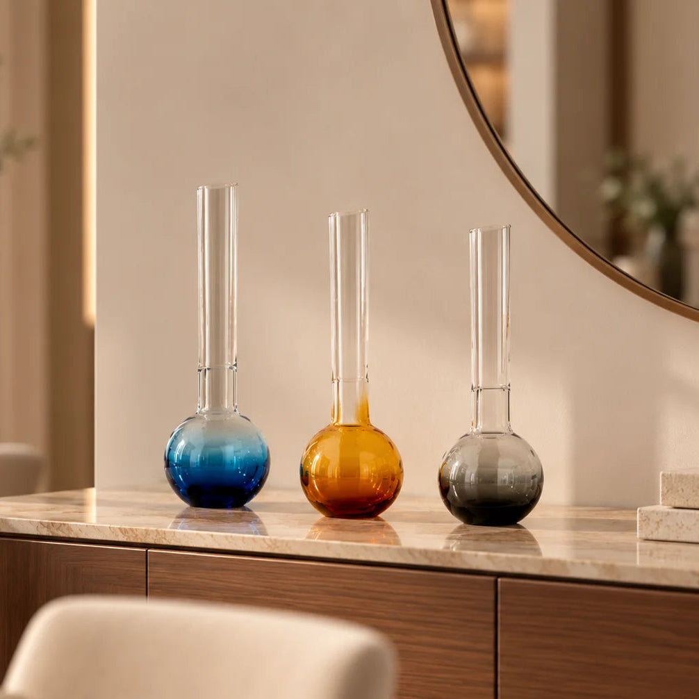 Glass vase with spherical base and elongated cylindrical neck designed for single stem floral arrangements