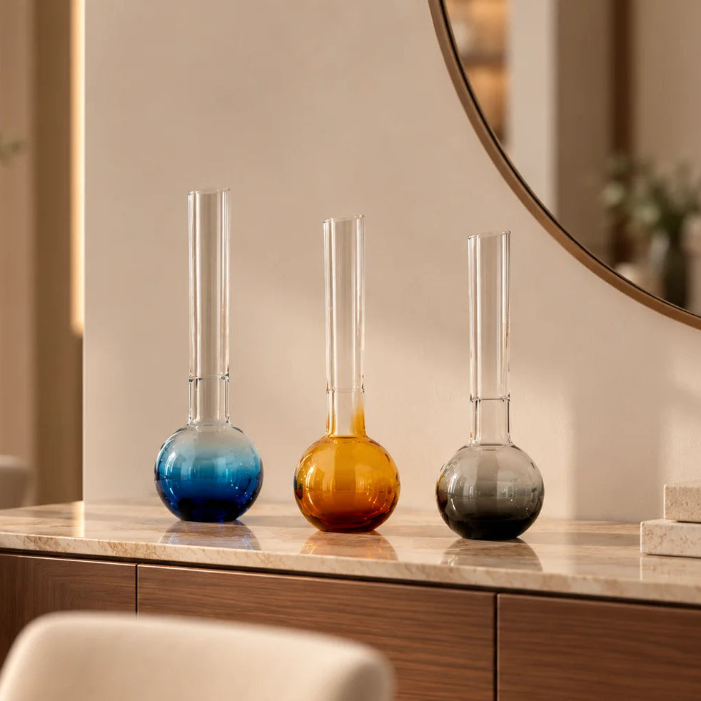 Glass vase with spherical base and elongated cylindrical neck designed for single stem floral arrangements