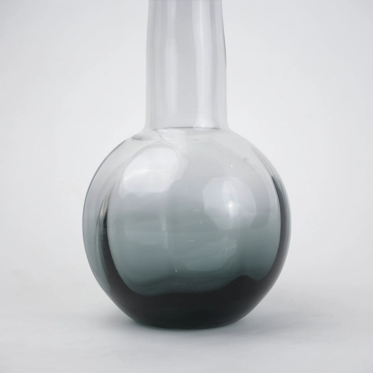 Glass vase with spherical base and elongated cylindrical neck designed for single stem floral arrangements