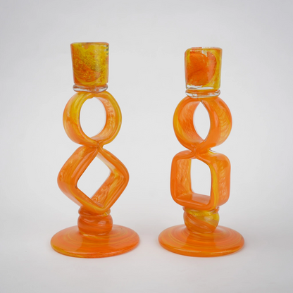 Orange art glass candle holder with geometric open frame and circular ring design