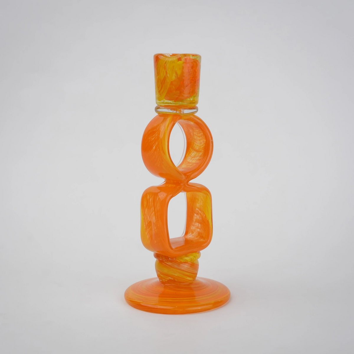 Orange art glass candle holder with geometric open frame and circular ring design