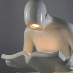 Glossy white reading sculpture lamp with abstract seated figure holding a book and built-in LED light.
