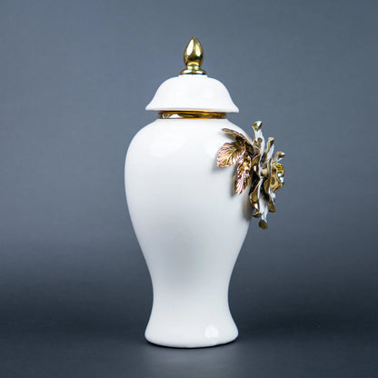 White ceramic jar with gold leaf design and lid on a