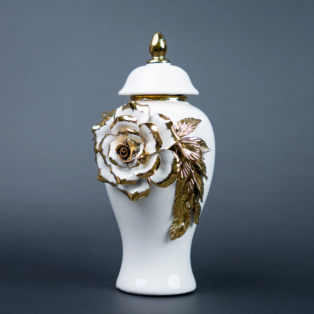 White ceramic jar with gold leaf design and lid on a