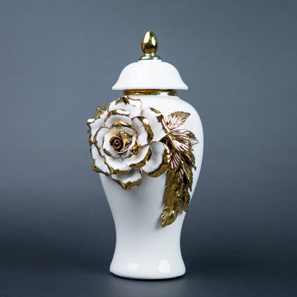 White ceramic jar with gold leaf design and lid on a