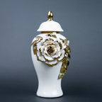 White ceramic jar with gold leaf design and lid on a