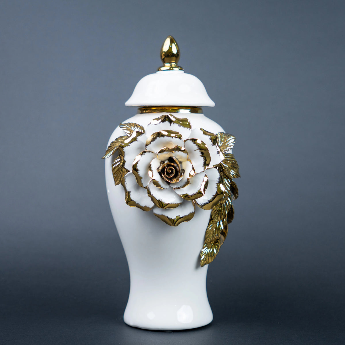 White ceramic jar with gold leaf design and lid on a